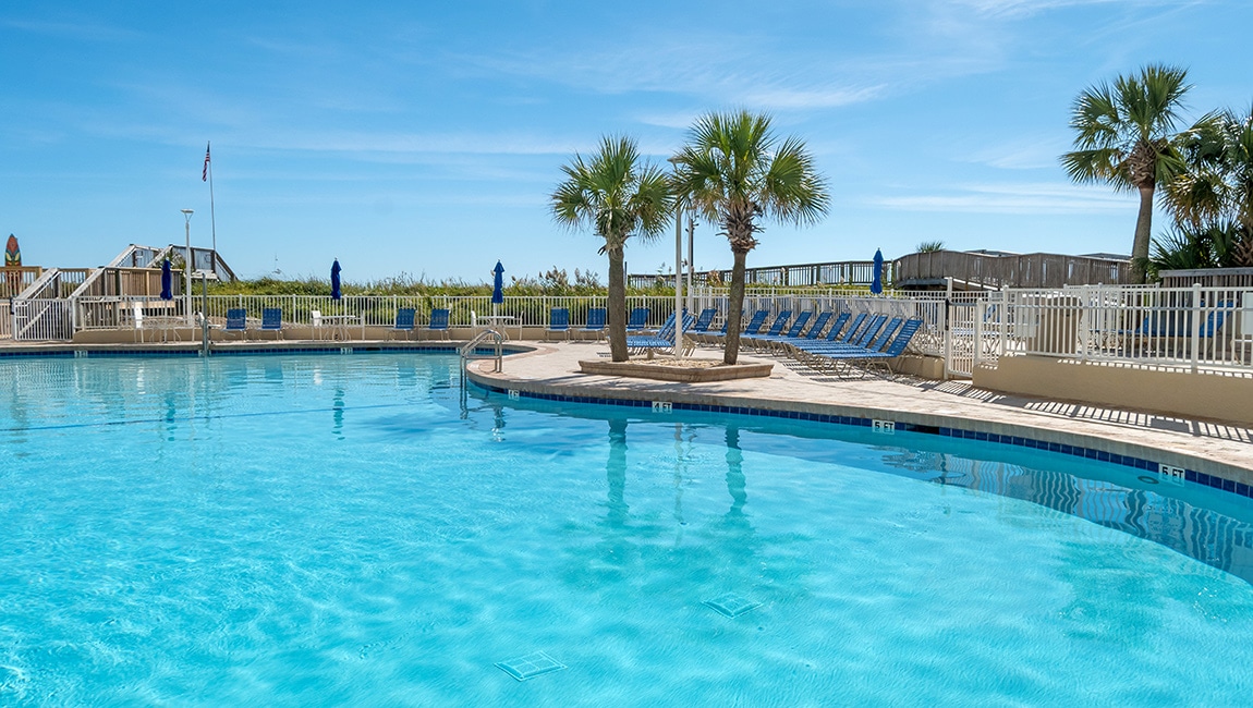 Pool and palm trees at Sea Watch Resort